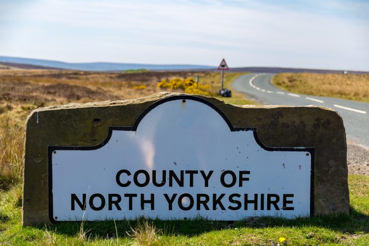 a sign showing that you are entering the county of North Yorkshire, which is situated at the side of a country road